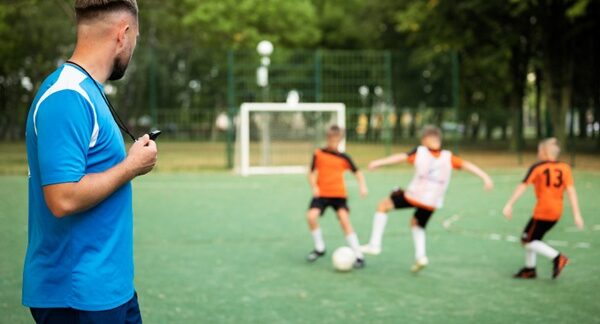 Escuelas de fútbol - Entrenador de una academia de fútbol dando clases a jóvenes en una de las mejores escuelas de fútbol en Valencia