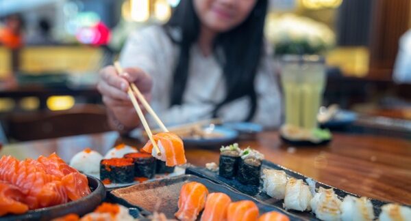 Mejores restaurantes japoneses - Mujer probando comida japonesa en uno de los mejores restaurantes japoneses en Valencia