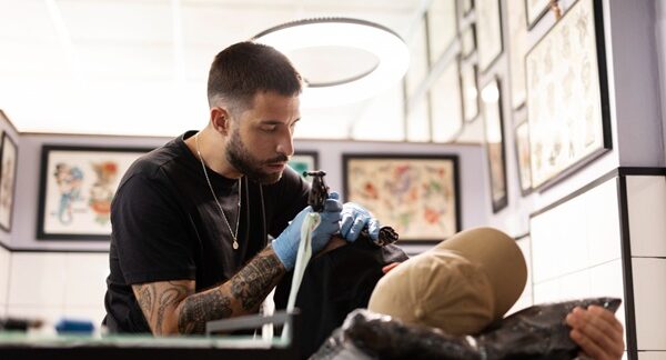 Mejores tatuadores - Tatuador reconocido como uno de los mejores tatuadores en Valencia realizando un tatuaje a un hombre