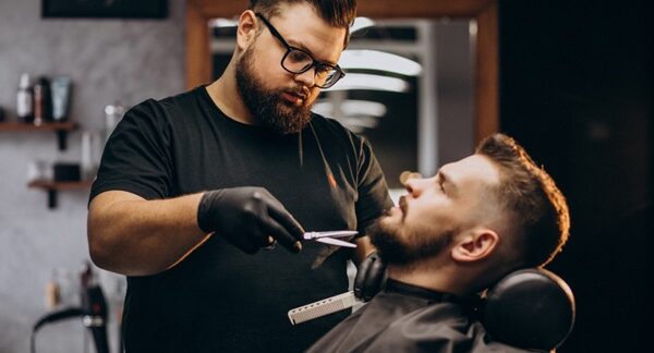 Barberías - Barbero realizando un corte de cabello a un hombre en una peluquería barbería reconocida como una de las mejores barberías en Valencia