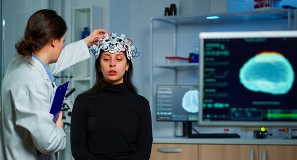 Centros para el dolor de cabeza - Neurólogo evaluando a una mujer con dolor de cabeza debido a migraña o cefalea en uno de los mejores centros para el dolor de cabeza en Valencia