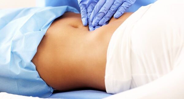 Cirujanos abdominales - Médico abdominal reconocido como uno de los mejores cirujanos abdominales de Valencia evaluando a una mujer con enfermedades abdominales
