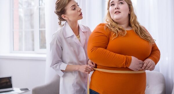 Centros de obesidad - Médico especialista en obesidad evaluando a una mujer con sobrepeso para ayudarla a adelgazar en uno de los mejores centros de obesidad de Valencia