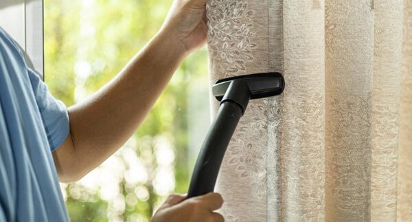 Servicios de lavado de cortinas - Personal de una de las mejores empresas de servicios de lavado de cortinas en Valencia realizando el mantenimiento de cortinas a domicilio