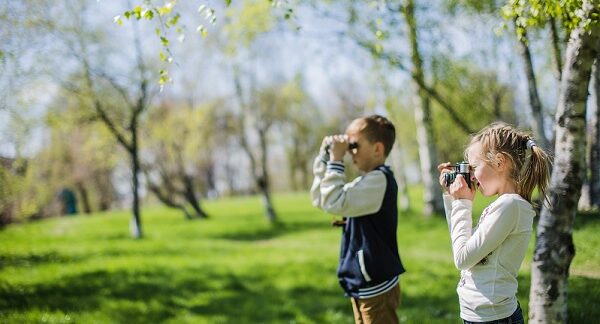 actividades para niños en edad preescolar, dos niños observan con binoculares en el parque
