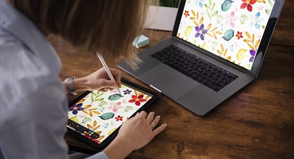 uno de los cursos de diseño gráfico, una mujer dibuja en su tableta grafica, un diseño floral