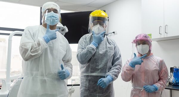 especialistas en enfermedades infecciosas vestidos con trajes especiales posan para una foto