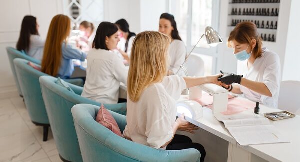 en uno de los salones de uñas, un grupo de mujeres se hacen procedimientos estéticos en las uñas con especialistas