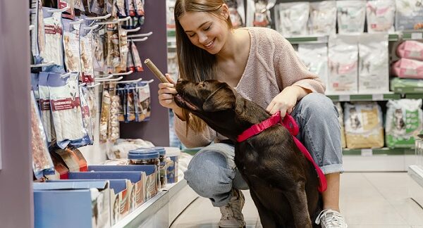 en una de las tiendas de juguetes para perros, una mujer selecciona un juguete para su mascota